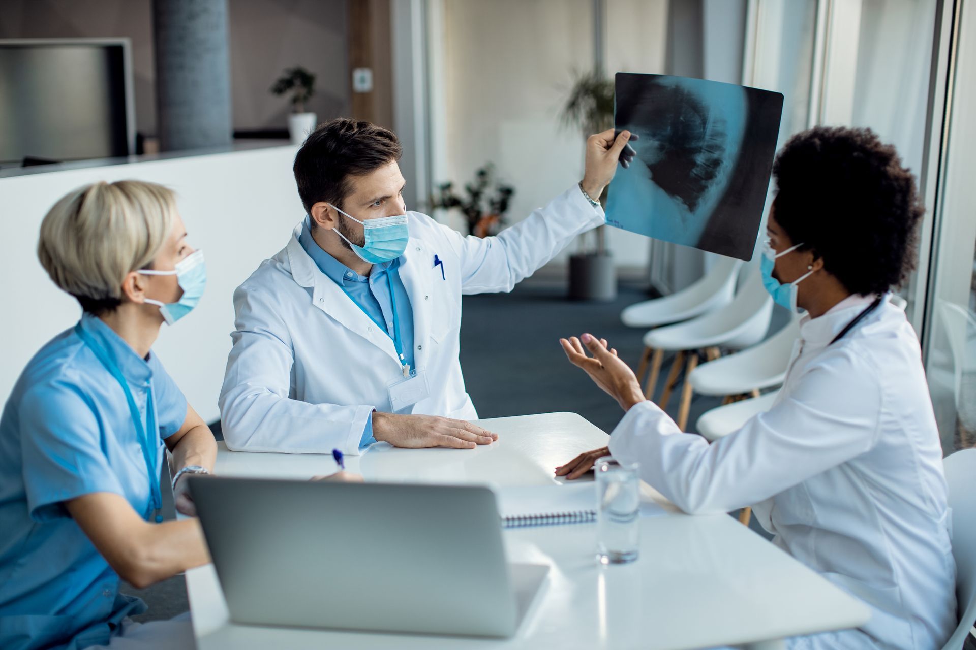 Doctors discussing an X-ray image, highlighting care coordination in patient management.