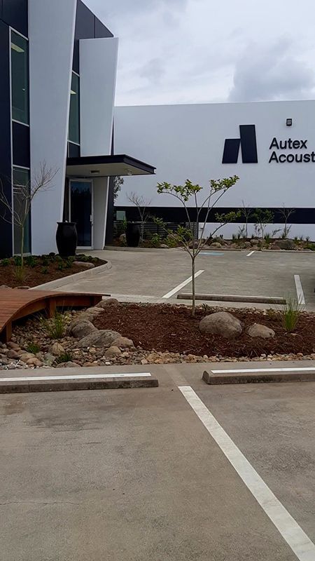 A Large Building With A Parking Lot In Front Of It — Full Circle Landscaping in Uki, NSW