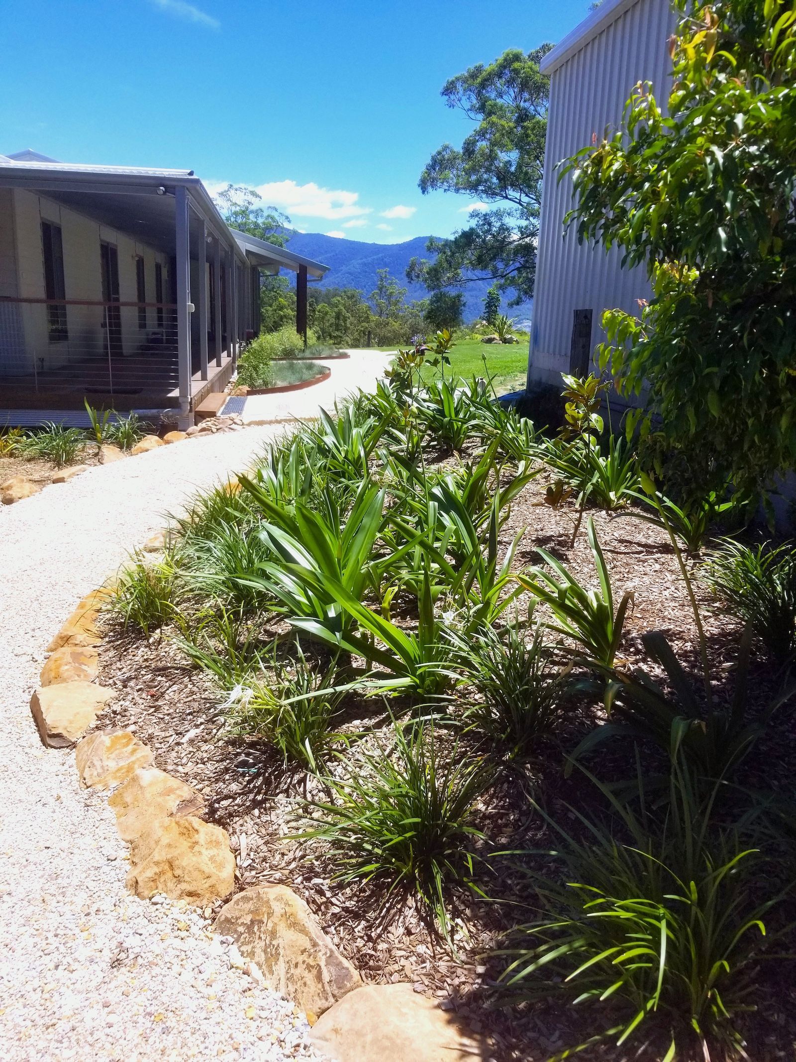 A Parking Lot In Front Of A Large Building With A Wooden Ramp Leading To It — Full Circle Landscaping in Uki, NSW