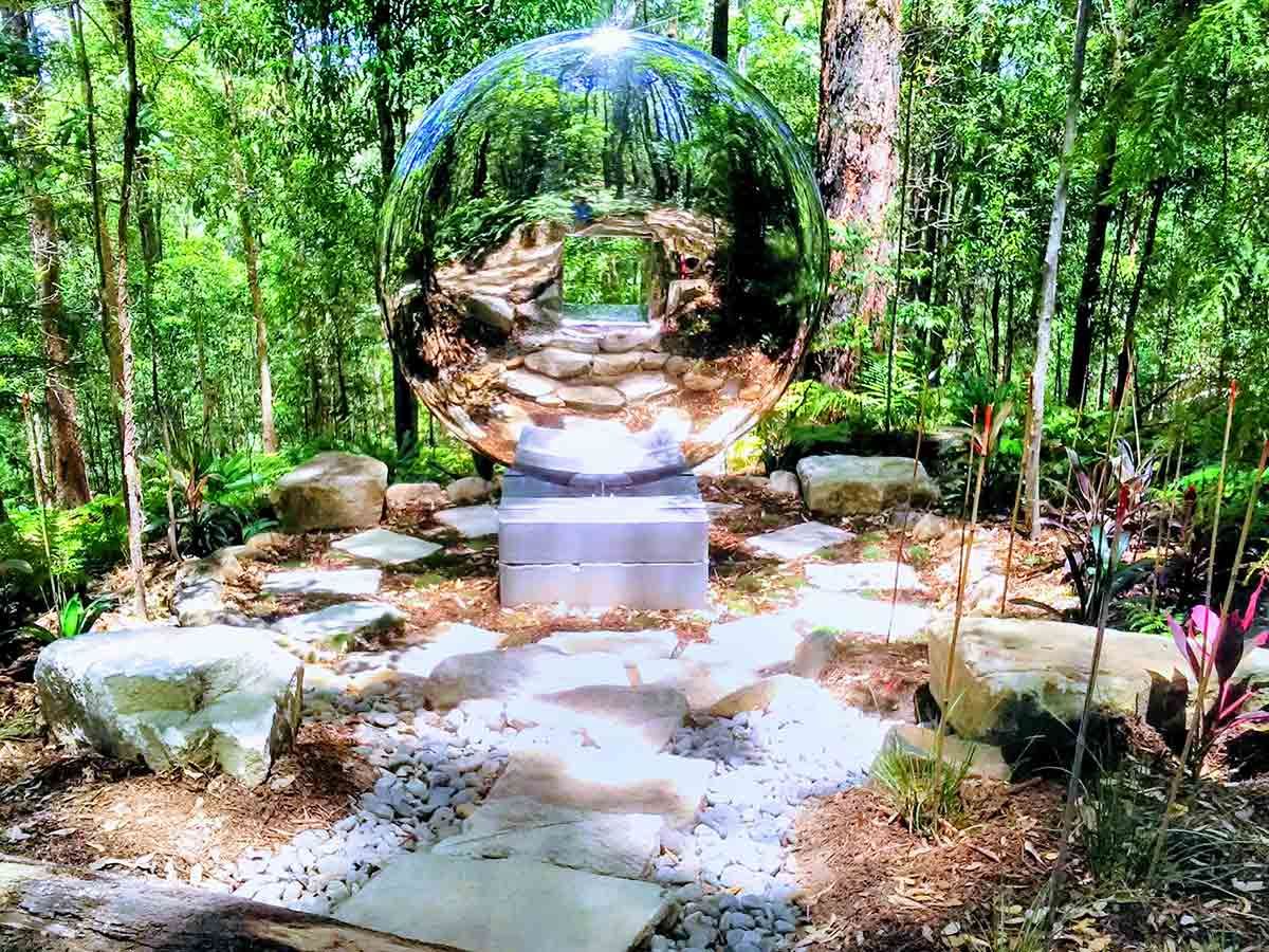 A Large Glass Ball is Sitting in the Middle of a Forest — Full Circle Landscaping in Tweed Heads, NSW