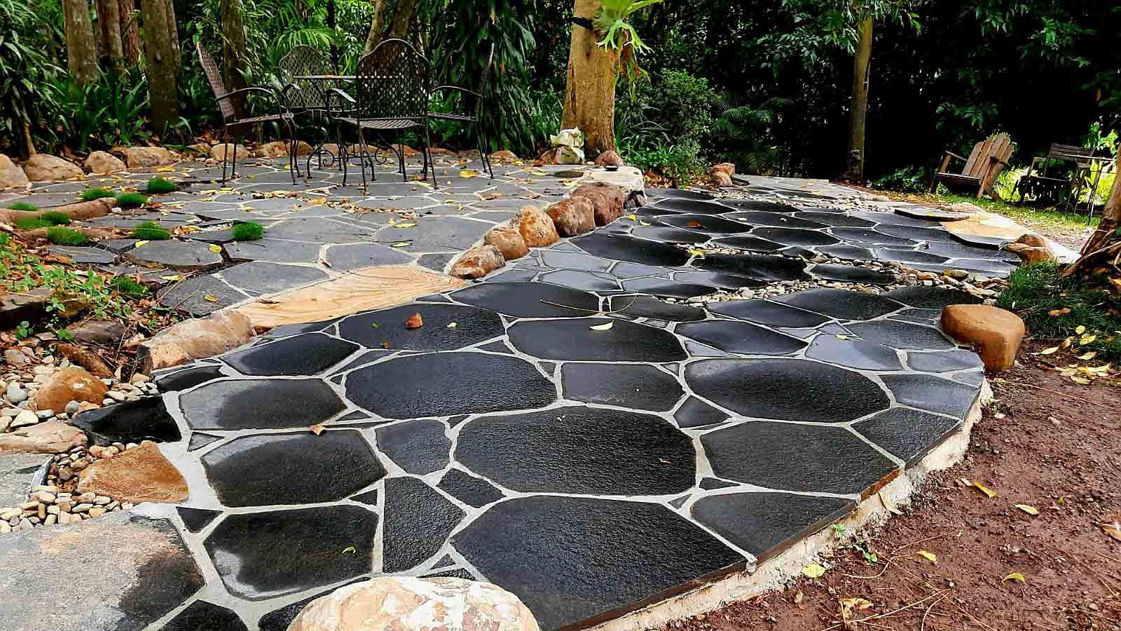 A Stone Walkway in a Garden With a Bench in the Background — Full Circle Landscaping in Ballina, NSW