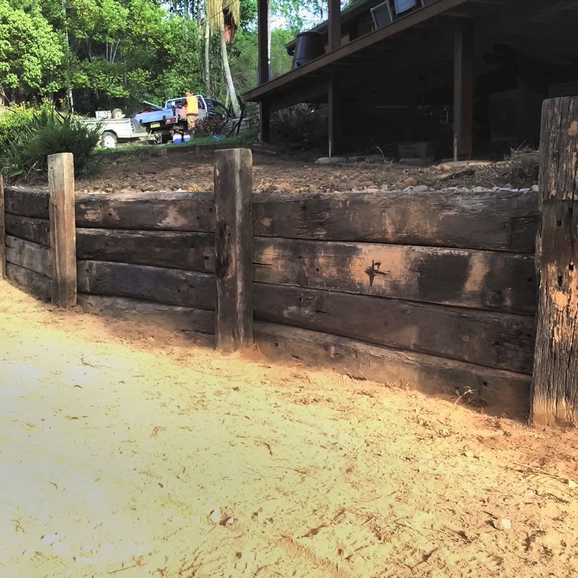 A Wooden Fence Is Surrounded By Dirt And Trees — Full Circle Landscaping in Uki, NSW