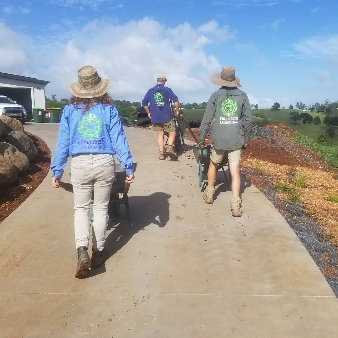A Group Of People Are Walking Down A Concrete Road — Full Circle Landscaping in Uki, NSW