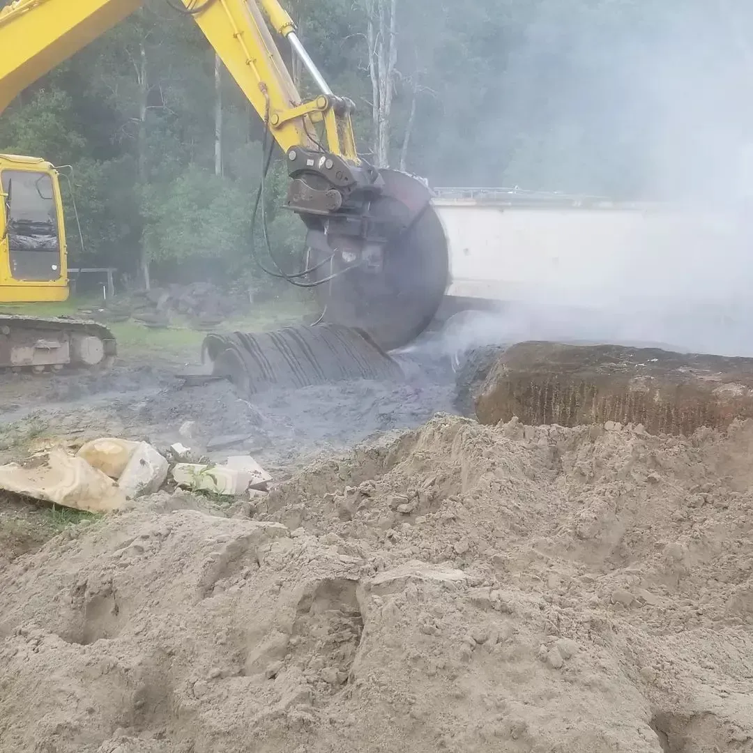 A Yellow Excavator Is Digging A Hole In The Ground — Full Circle Landscaping in Uki, NSW
