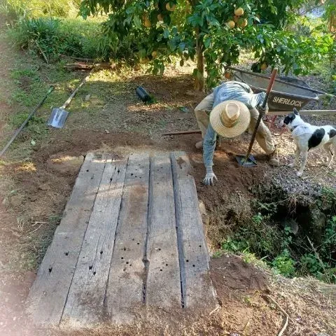A Man And A Dog Are Working On A Wooden Bridge — Full Circle Landscaping in Uki, NSW