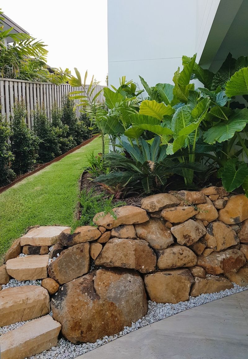 A Pile Of Rocks Is In The Dirt Next To A Stone Wall — Full Circle Landscaping in Uki, NSW