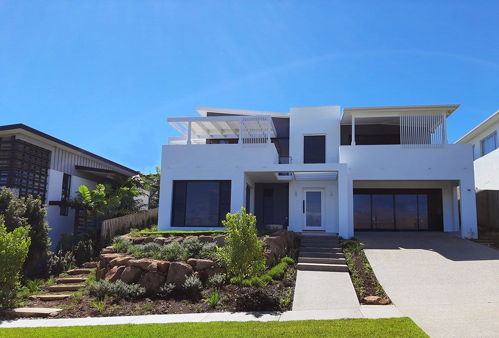 A Large White House Is On Top Of A Hill — Full Circle Landscaping in Uki, NSW