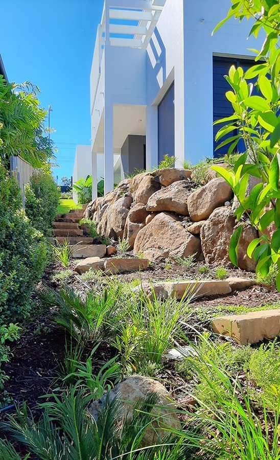 A House With Stairs Leading Up to It and a Rock Wall in Front of It — Full Circle Landscaping in Alstonville, NSW