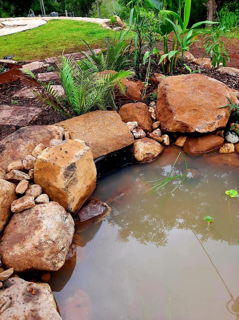 A Small Swimming Pool Surrounded By Rocks And Plants — Full Circle Landscaping in Uki, NSW