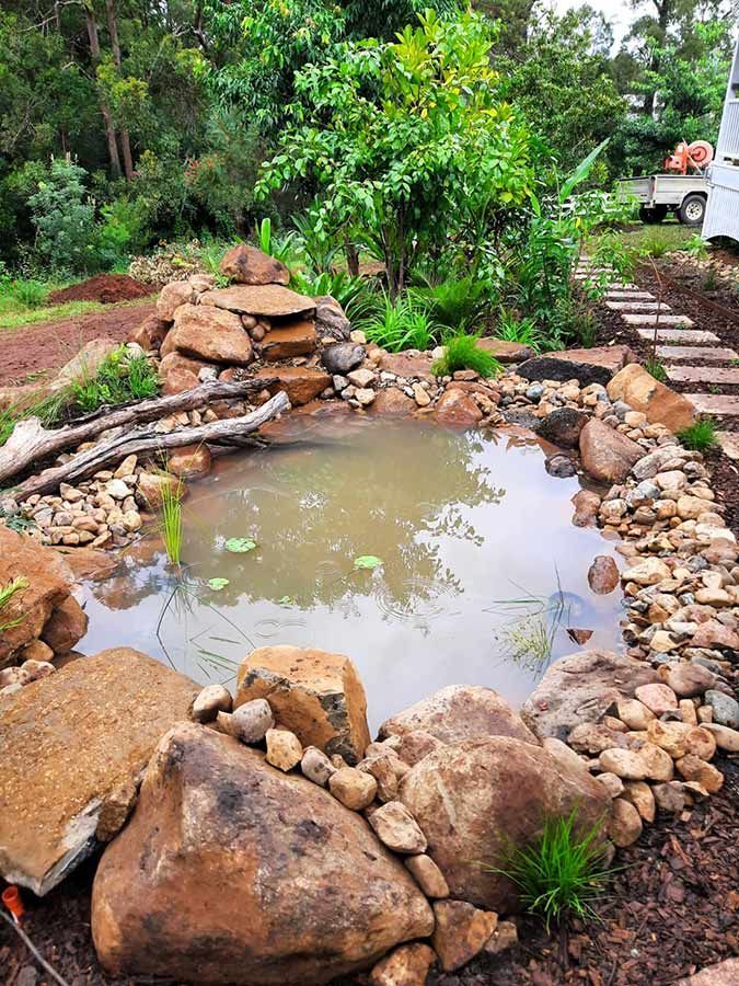 A Small Pond Surrounded by Rocks and Plants in a Garden — Full Circle Landscaping in Alstonville, NSW