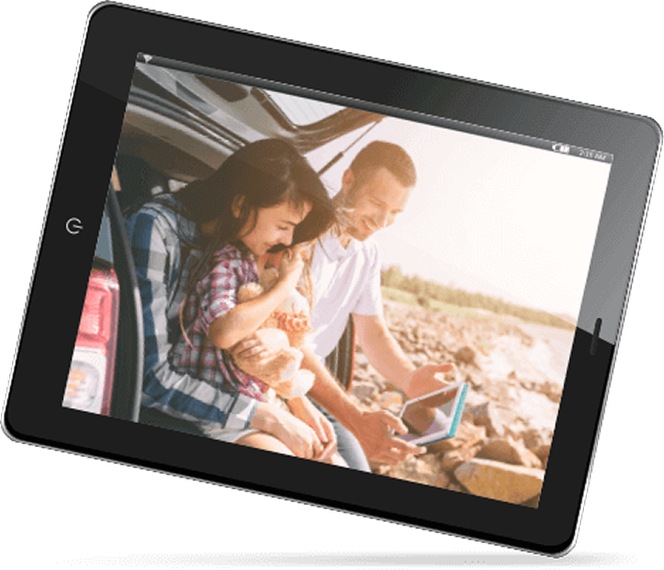Family smiling, looking at a tablet together, next to a car, outdoor setting. | Fincastle Automotive