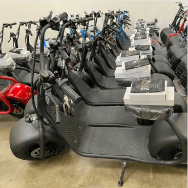 a row of scooters are lined up in a warehouse