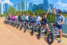 A group of people are standing next to each other on scooters IN AUSTIN TEXAS