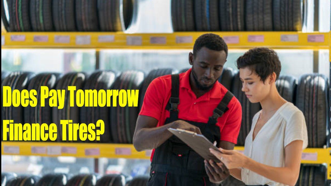 a man and a woman are looking at a clipboard in a tire store .