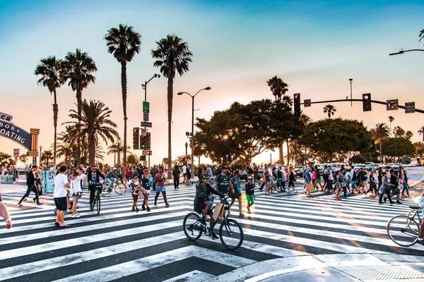 A man is riding a bike through a crowded intersection in Los Angeles.
