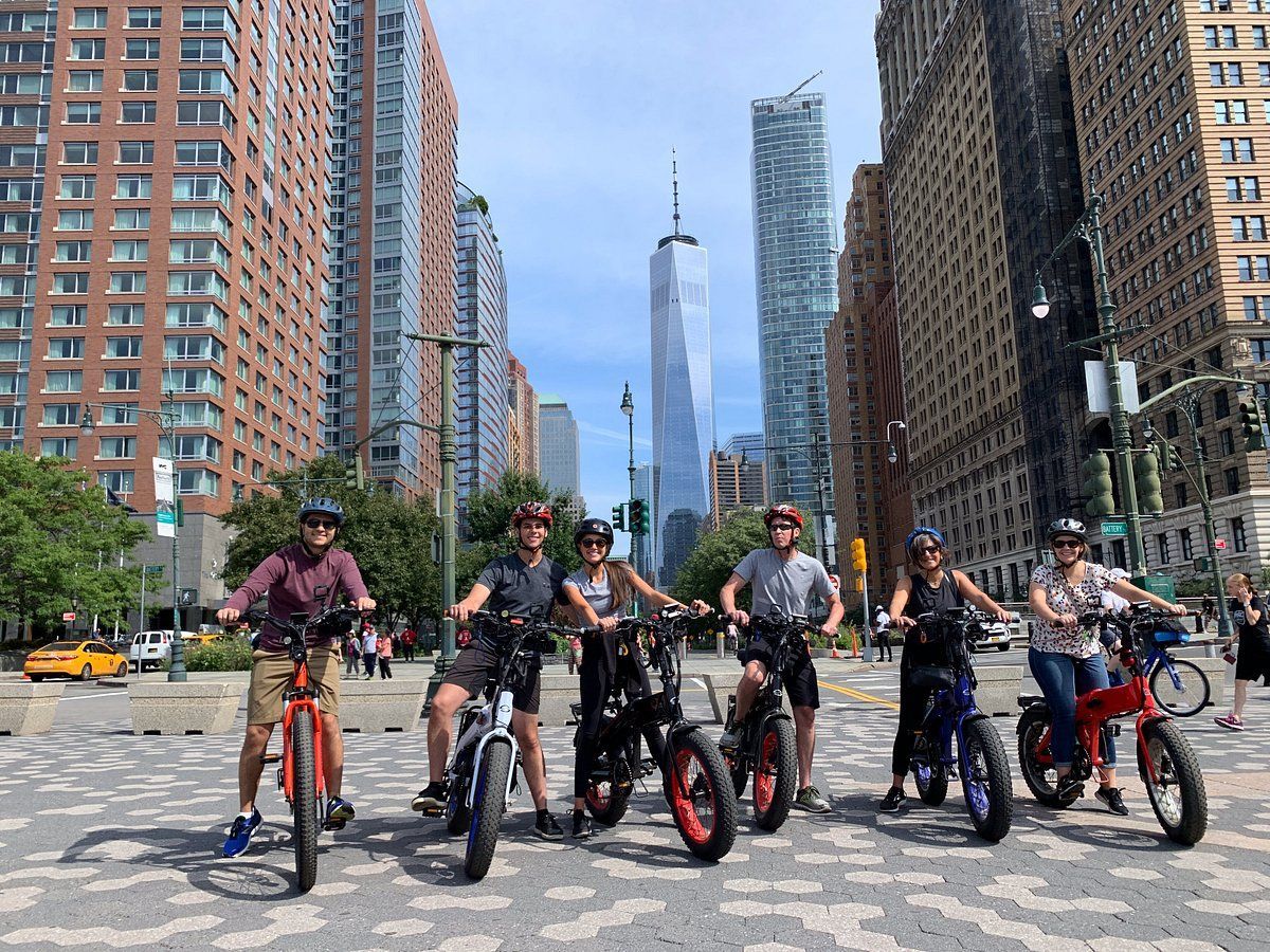 A group of people are standing next to each other on bicycles on a city street in New York
