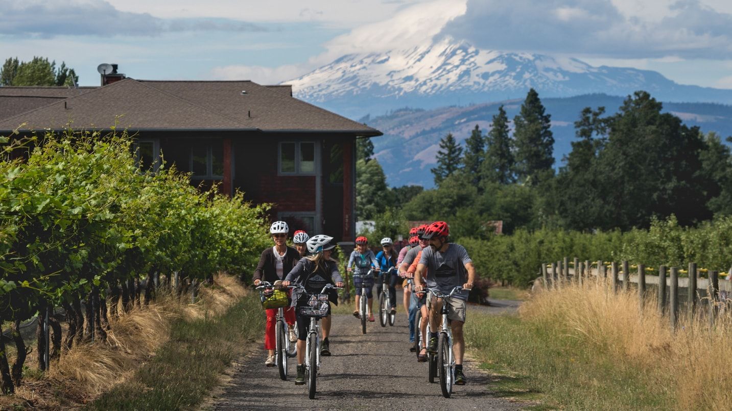 A group of people are riding bikes down a path in front of a house in Portland OR