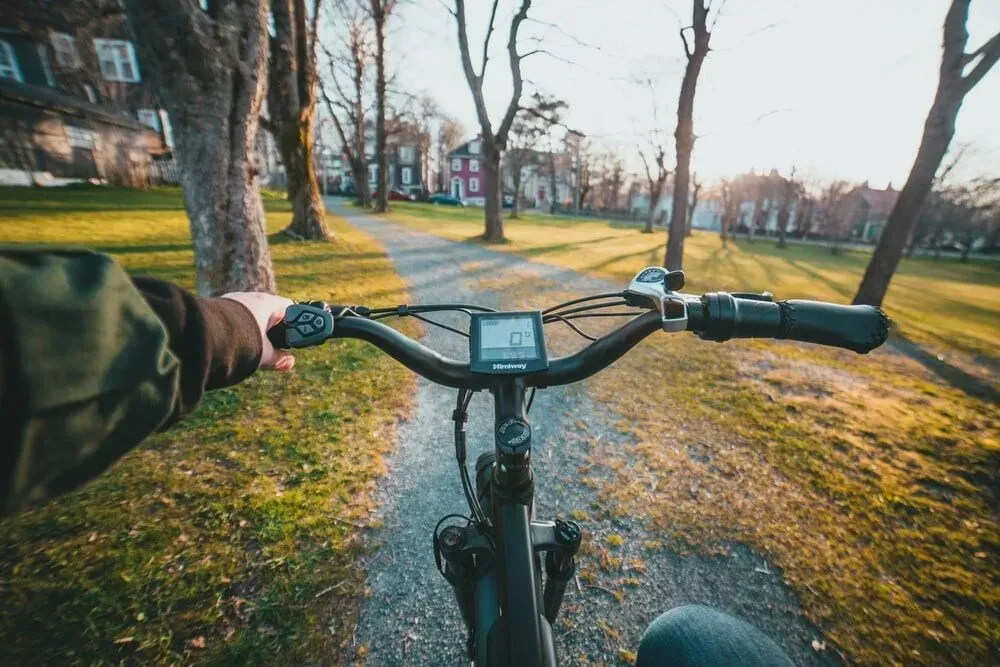 A person is riding an electric bike on a path in a park in Washington D. C.