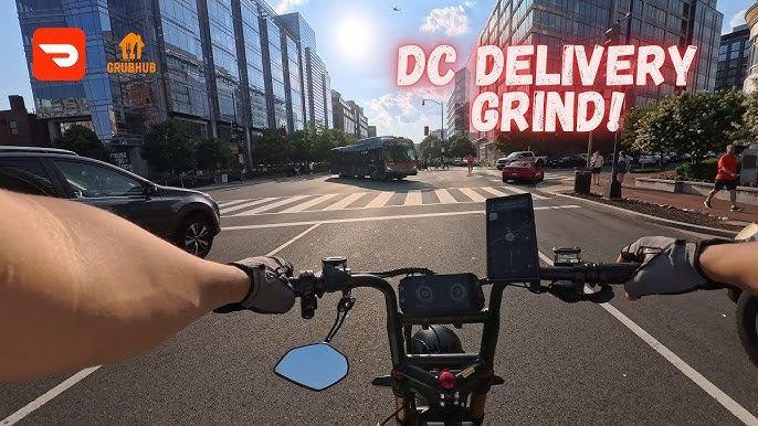 A person is riding an e-bike down a D. C. city street.
