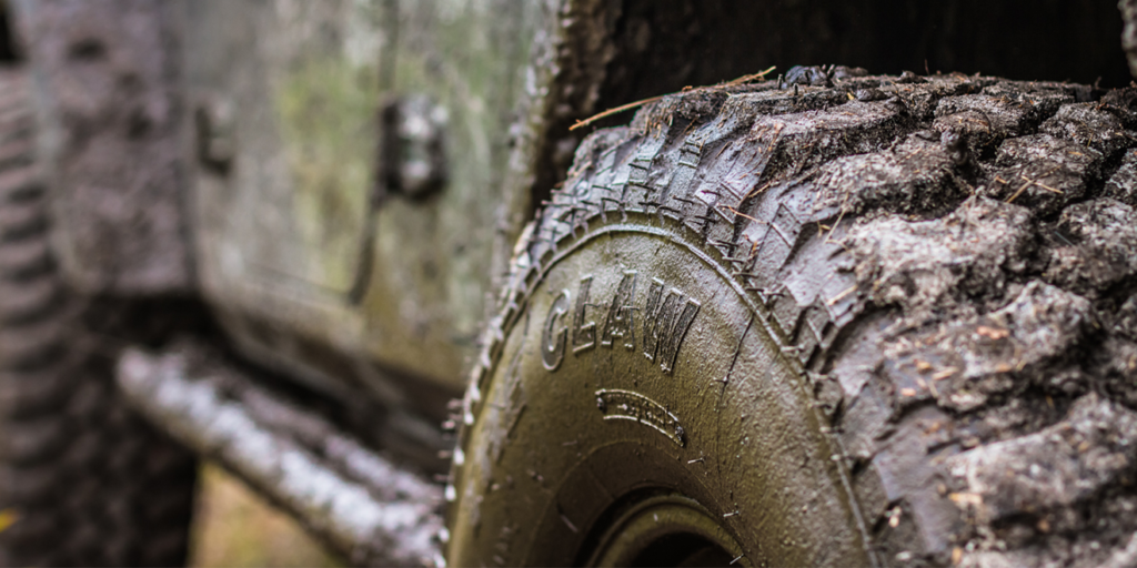 a close up of a muddy tire on a jeep .