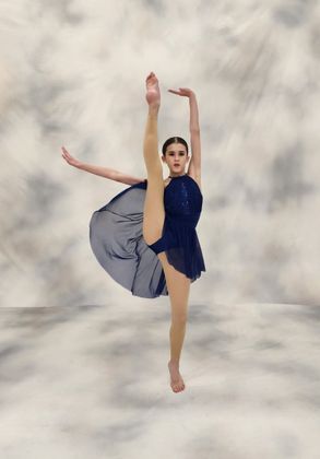 A Woman in A Blue Dress Is Doing a Split in The Air.