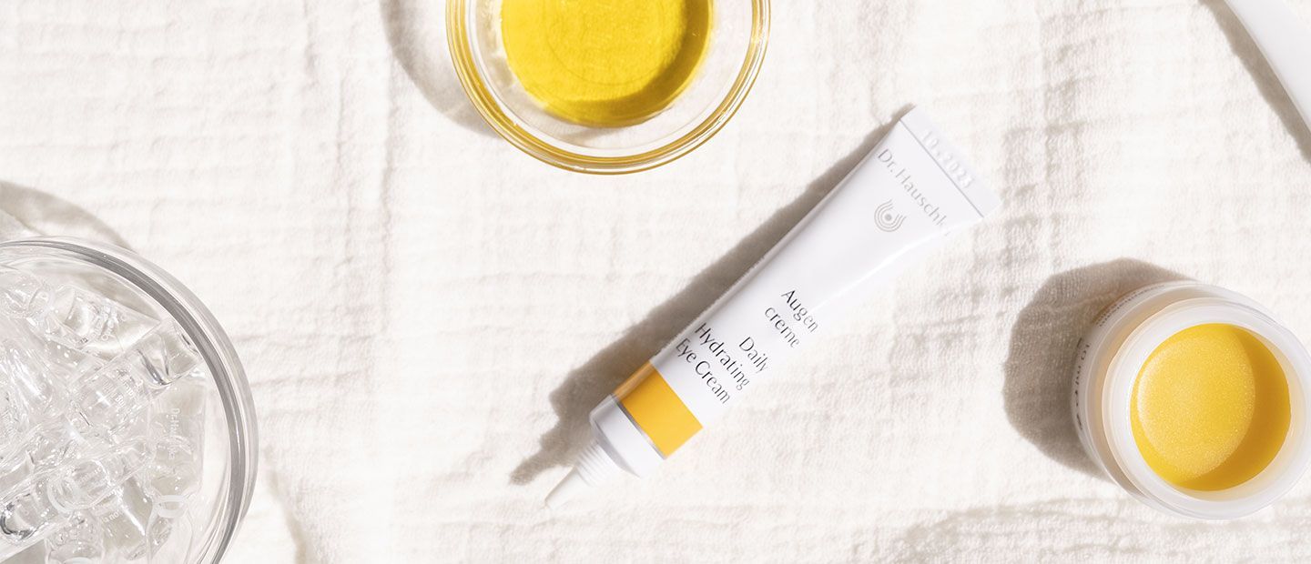 a wooden table topped with potted plants and tubes of lotion .
