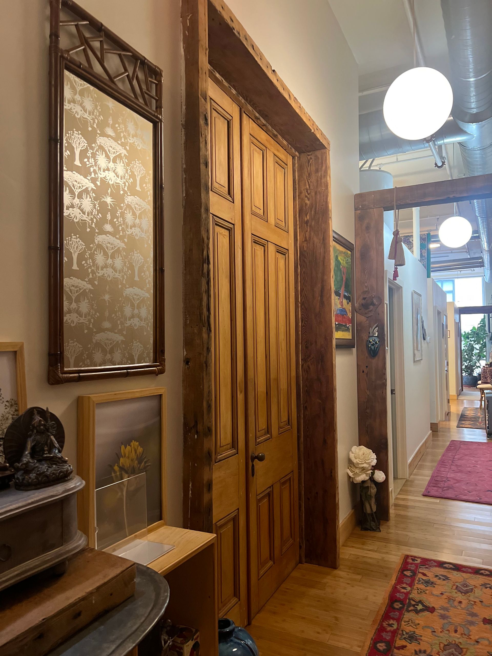 a hallway with wooden doors and a mirror on the wall .