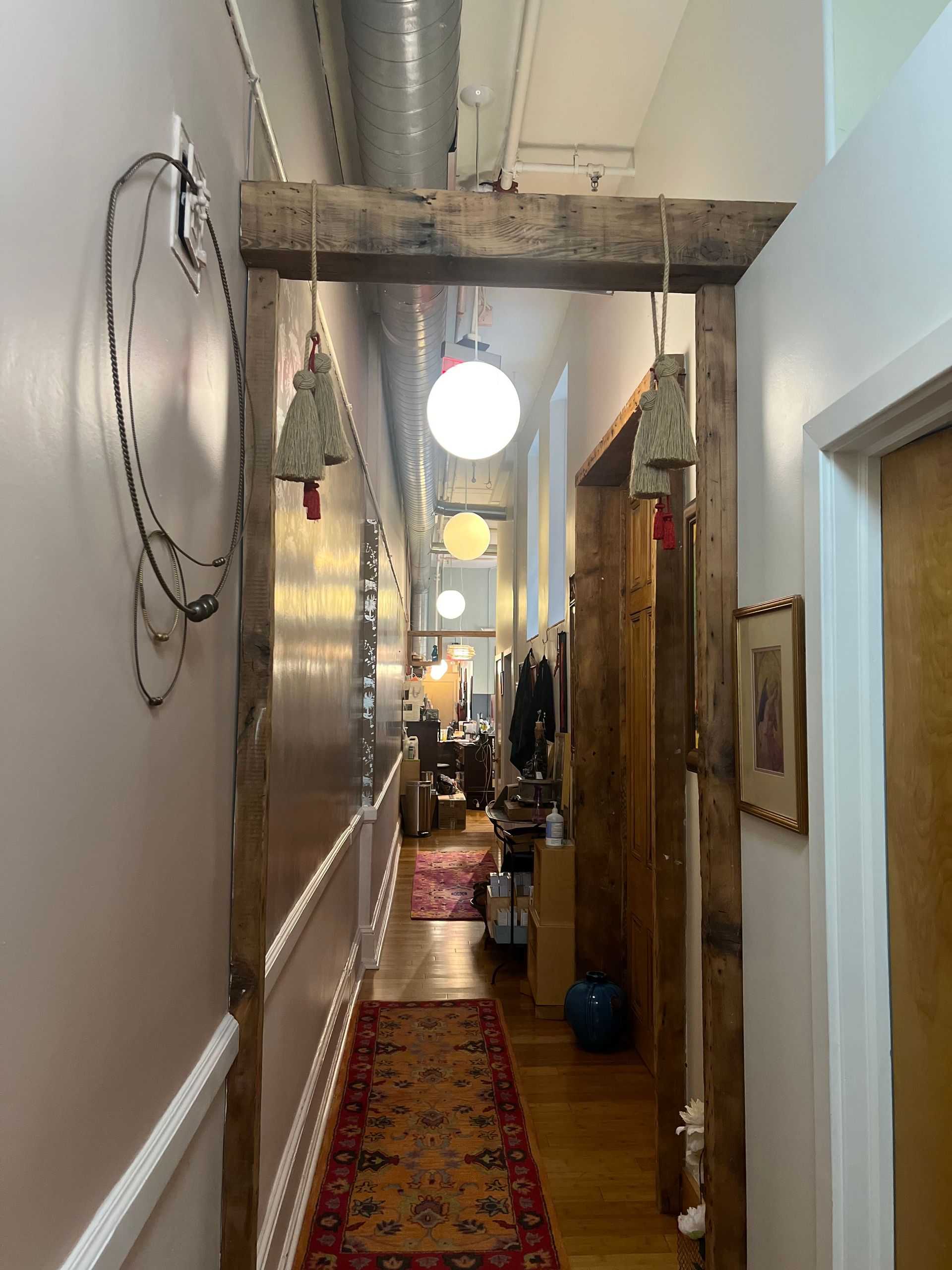 a long hallway with a wooden beam hanging from the ceiling
