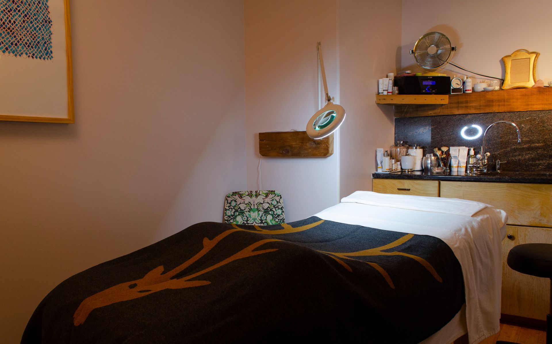 a massage table with a black and gold blanket in a room .