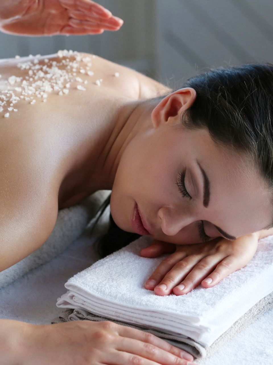 a woman is getting a massage with sea salt on her back