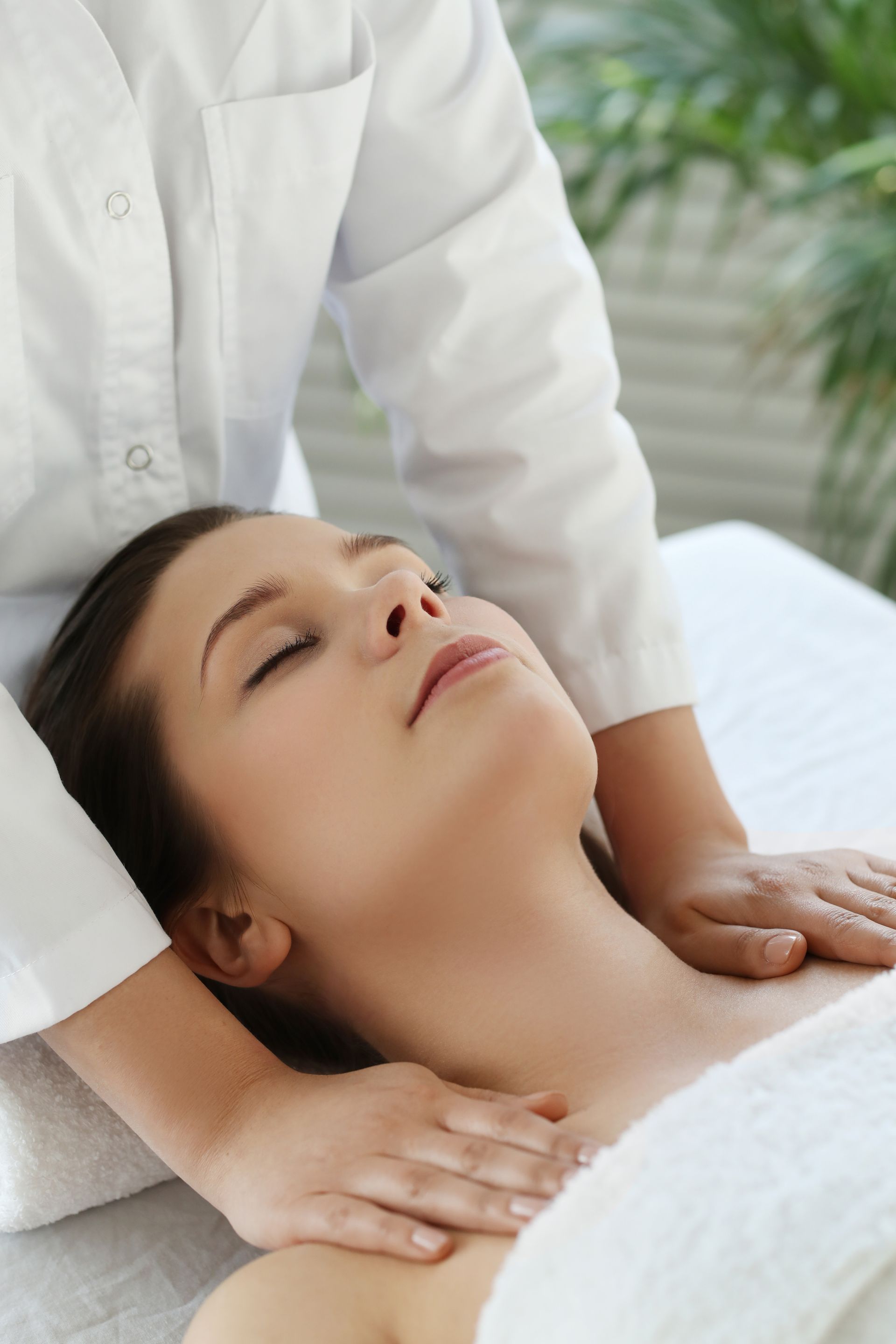 a woman is getting a massage with her eyes closed