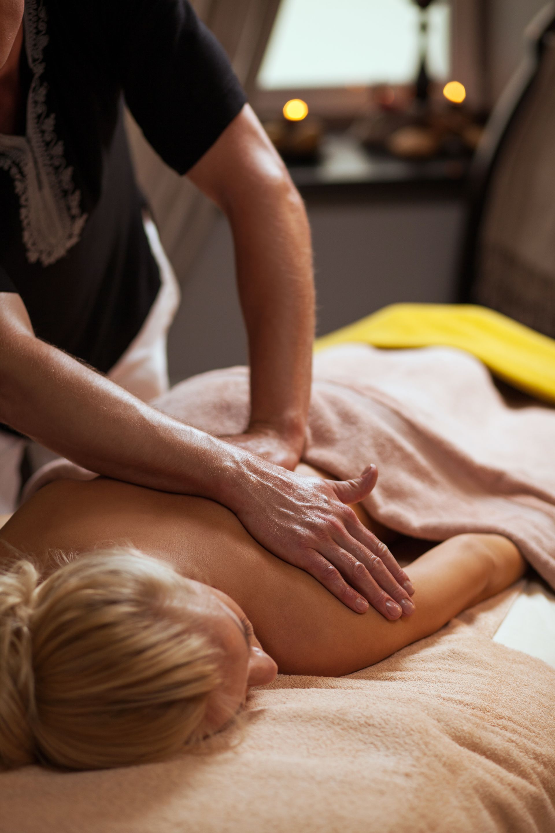 A professional masseuse giving a back massage.