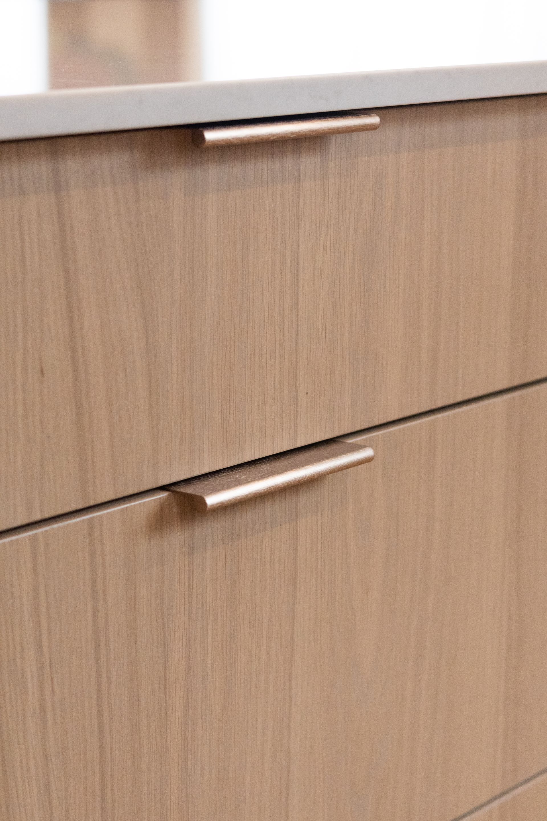 Tiroirs en bois avec poignées en or rose.