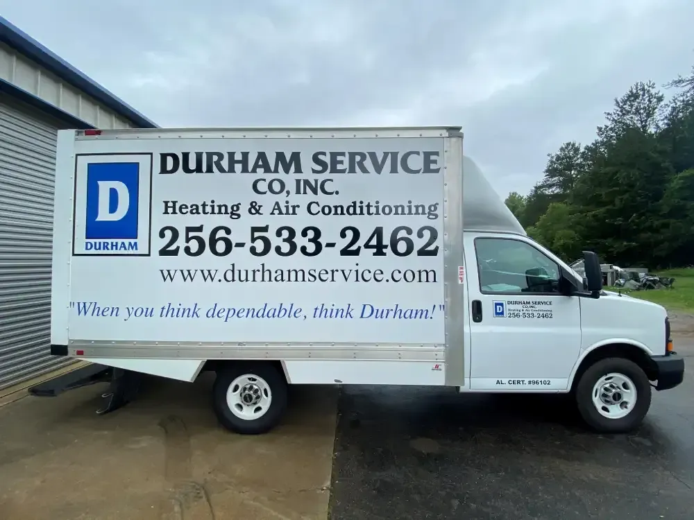 Durham Service Co. truck with heating and air conditioning logo parked beside a building