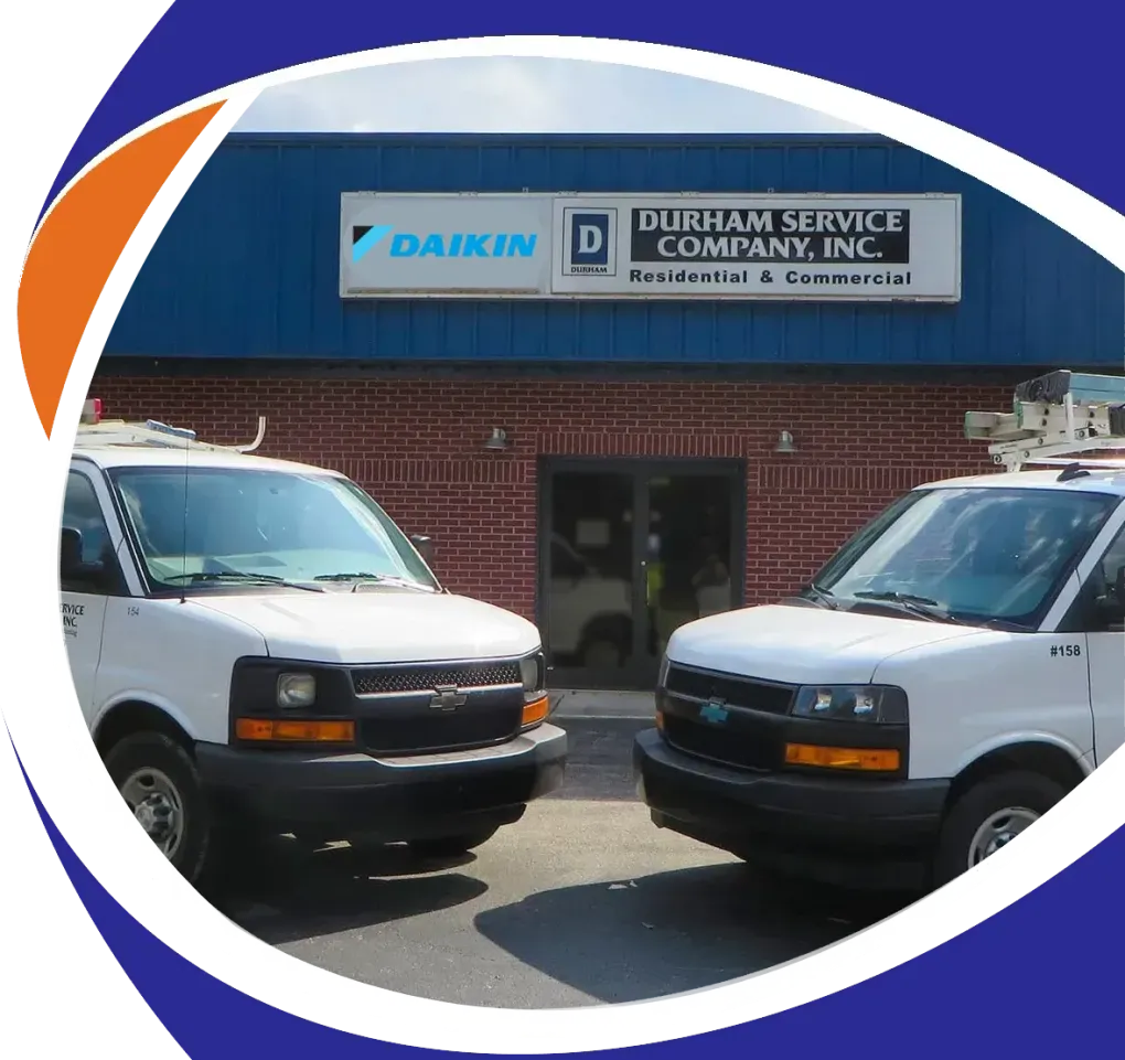 Two white service vans parked outside a Daikin HVAC company building
