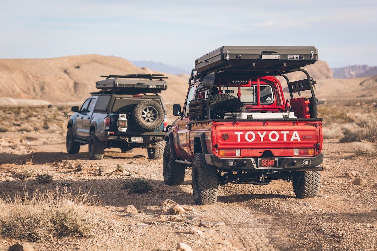 A Red And A Blue 4X4 Are Driving Along A Dirt Road — Marcoola Tyre & Mechanical In Marcoola, QLD
