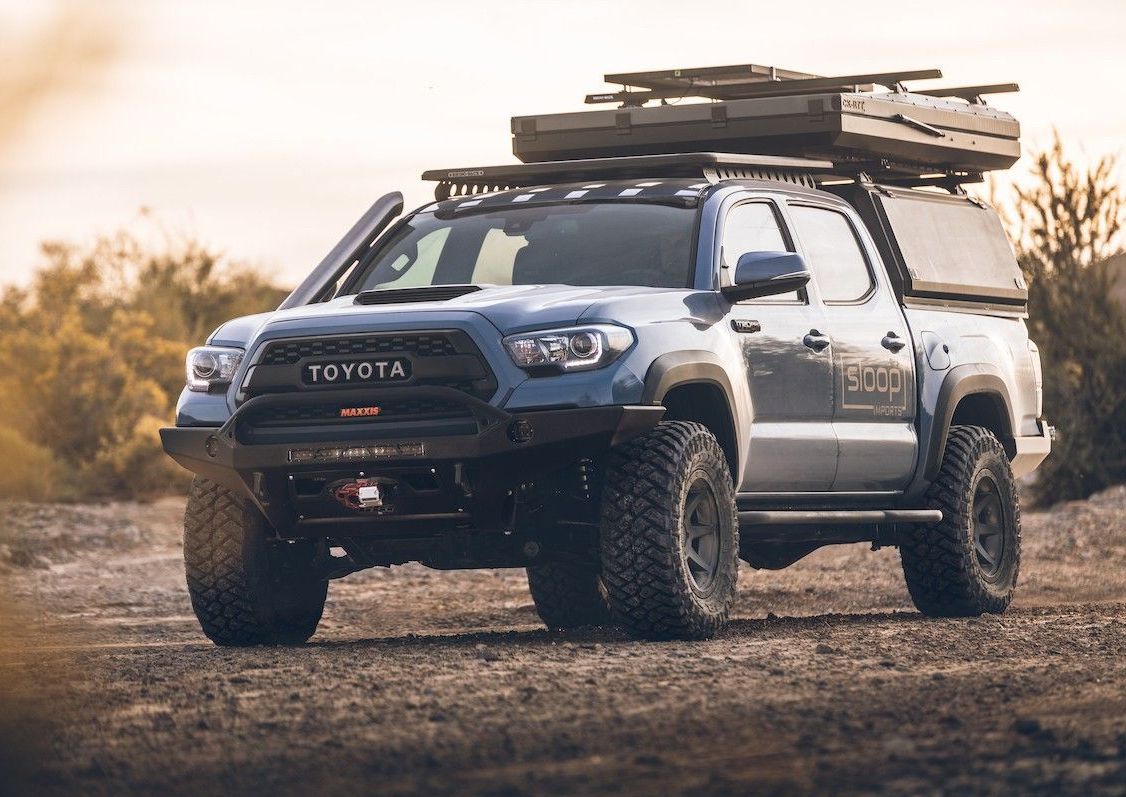 A Blue Toyota With A Roof Top Tent Is On A Dirt Road — Marcoola Tyre & Mechanical In Marcoola, QLD