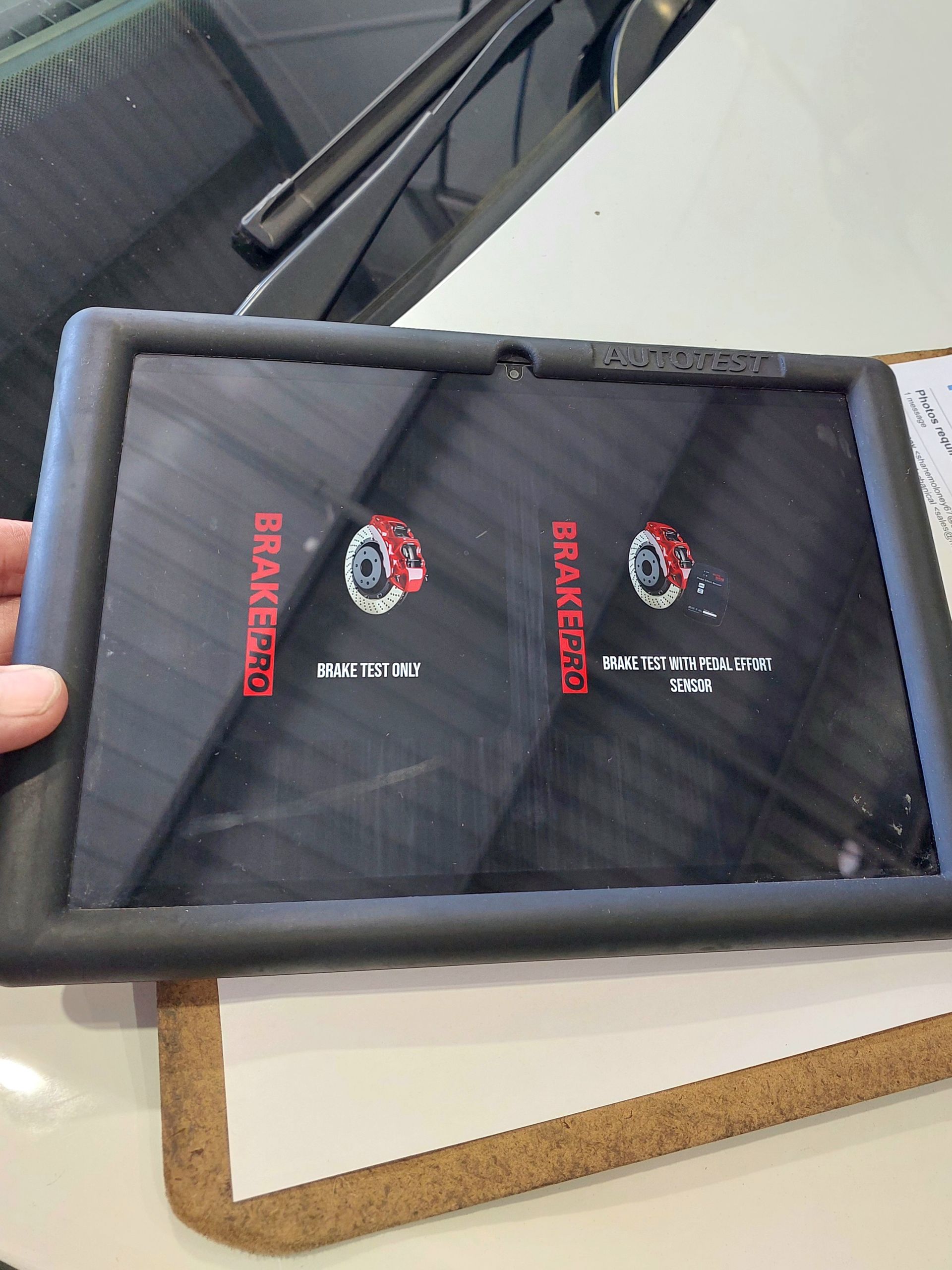Technician Holding A Diagnostic Screen Displaying Brake Test Options — Marcoola Tyre & Mechanical In Marcoola, QLD
