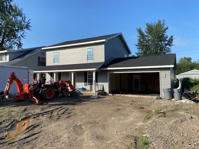 A house with a tractor parked in front of it