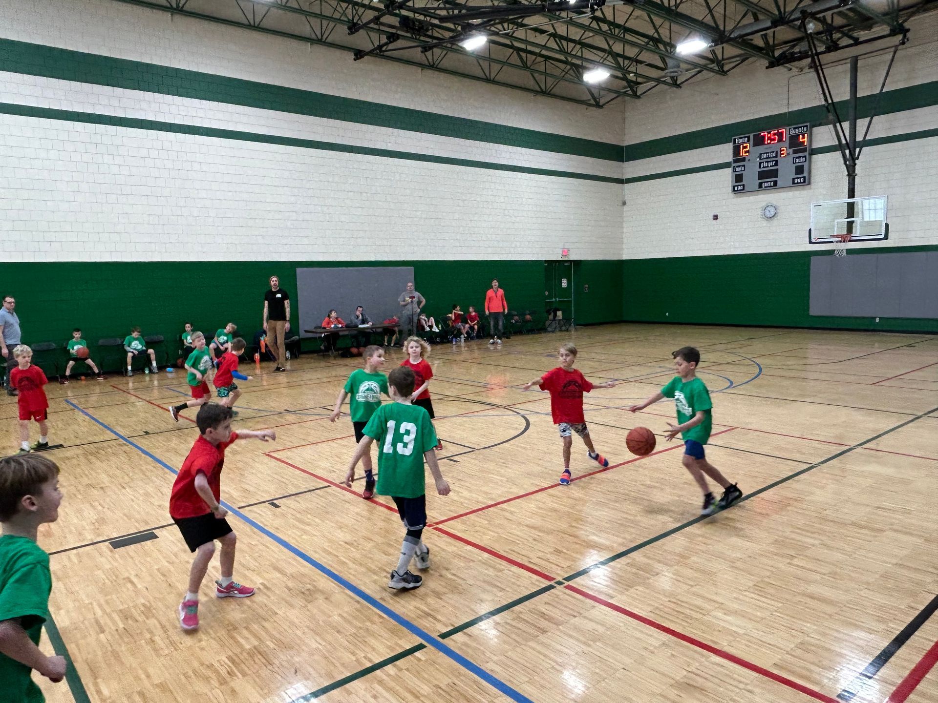 Youth Basketball - green jersey team vs red jersey team. Coaches in the background.