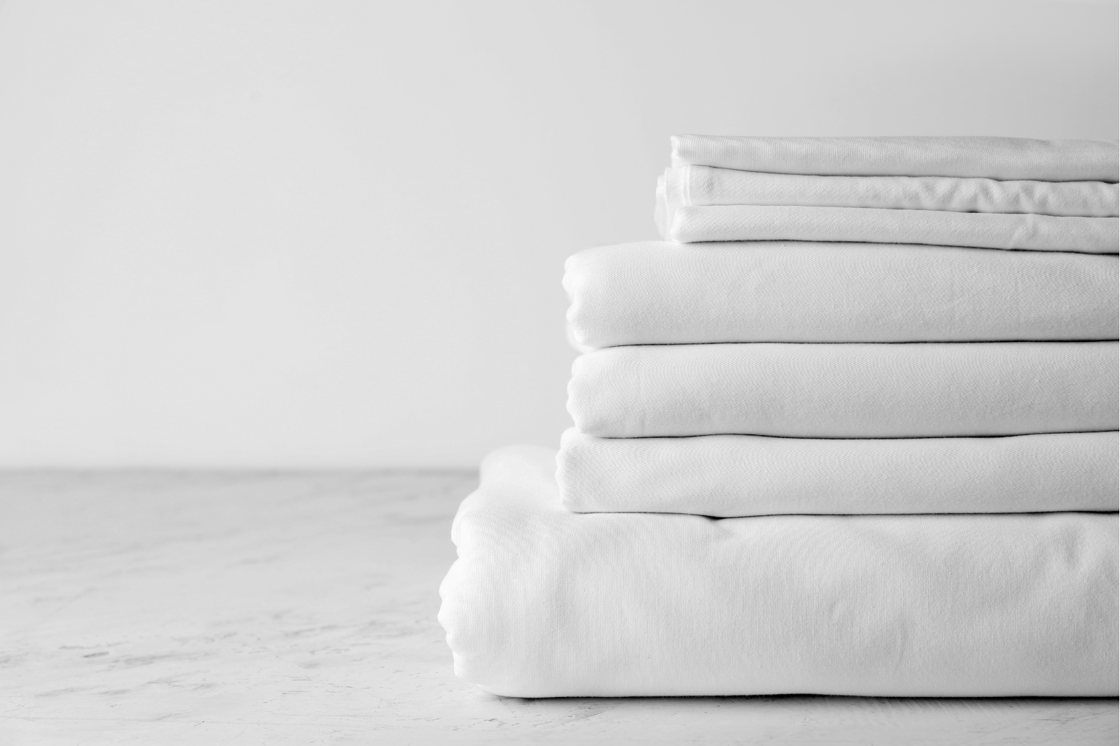 A stack of white towels sitting on top of each other on a table.