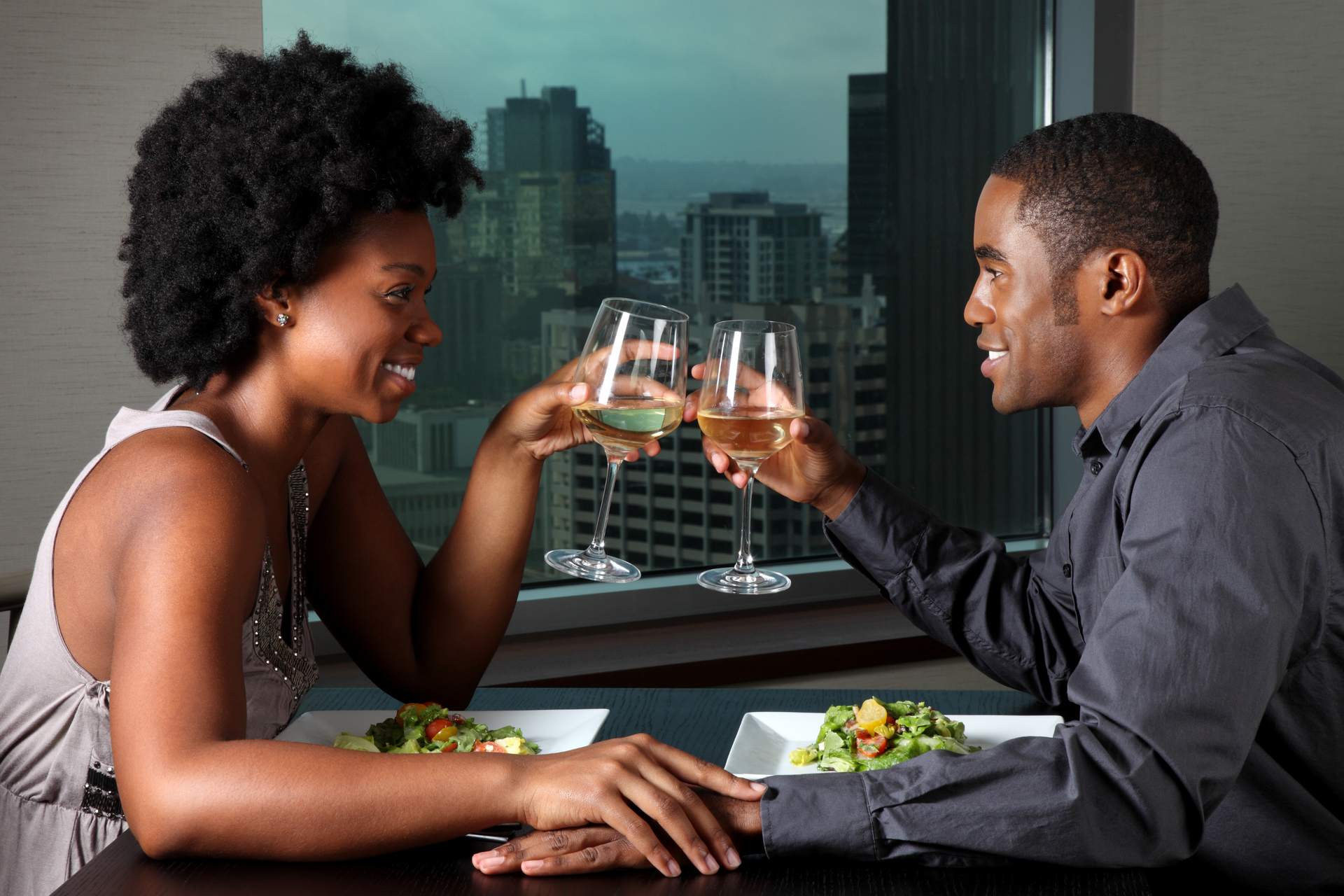 A man and a woman are toasting with wine glasses