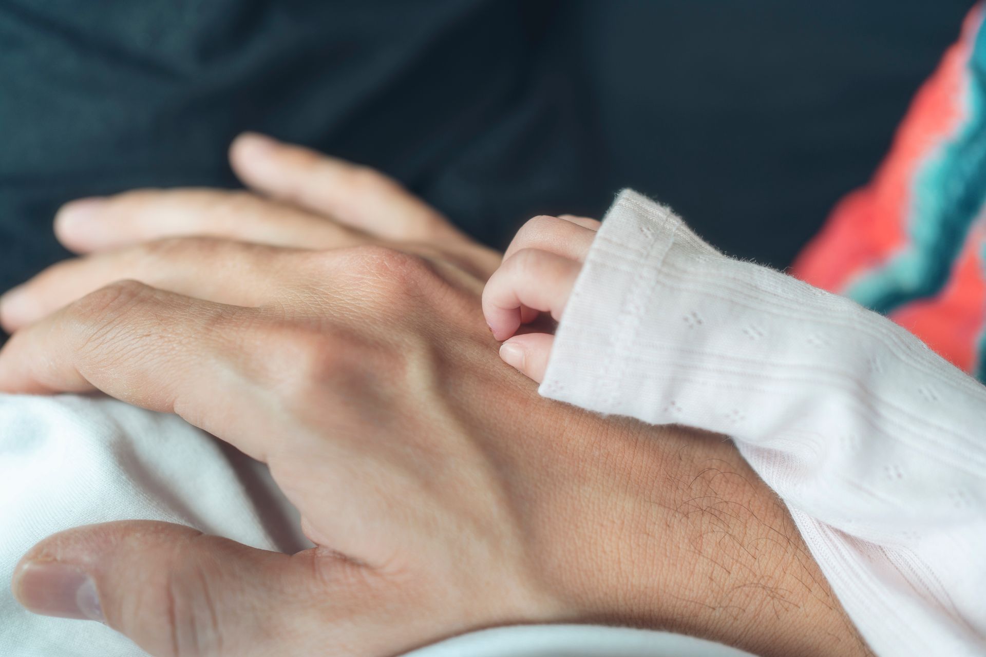 A father holding his newborn daughter's hand A father holding his newborn daughter's hand