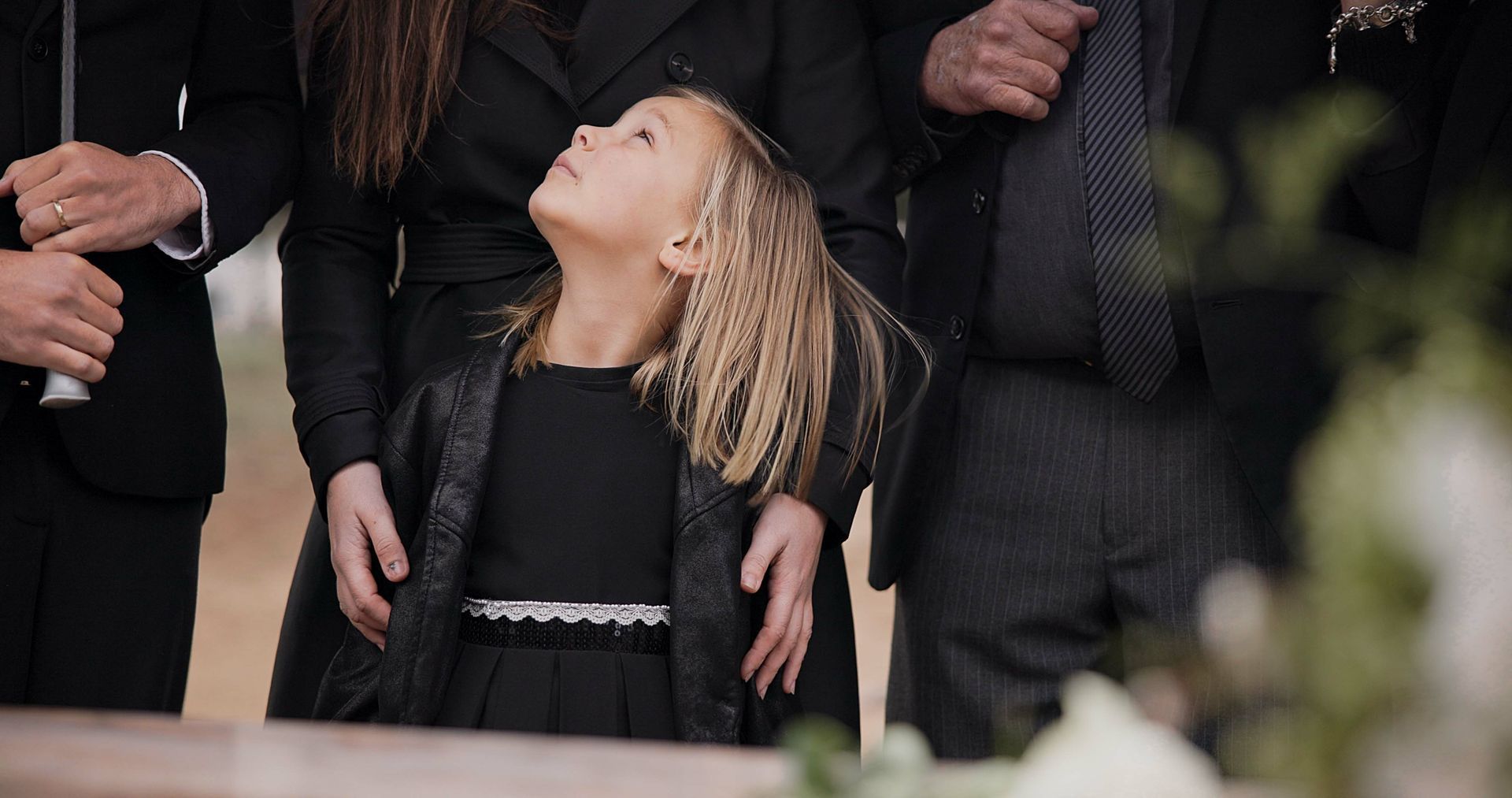 A little girl is hugging a man in a park.