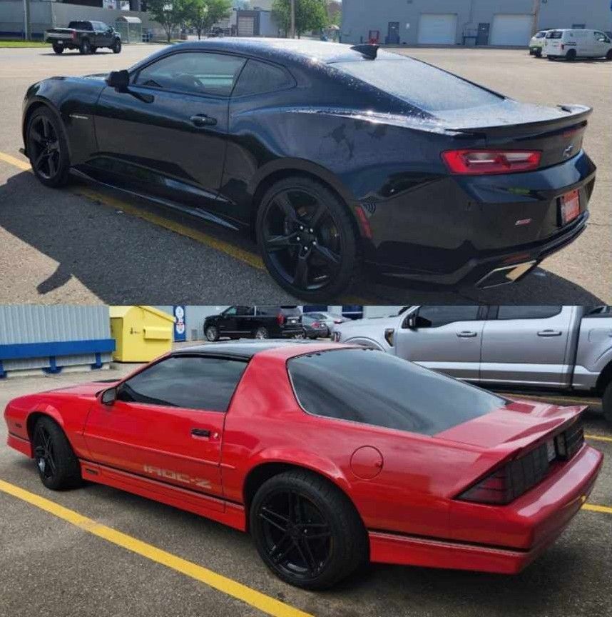 Black and red Chevrolet Camaros parked on asphalt in an outdoor setting, both with black wheels.