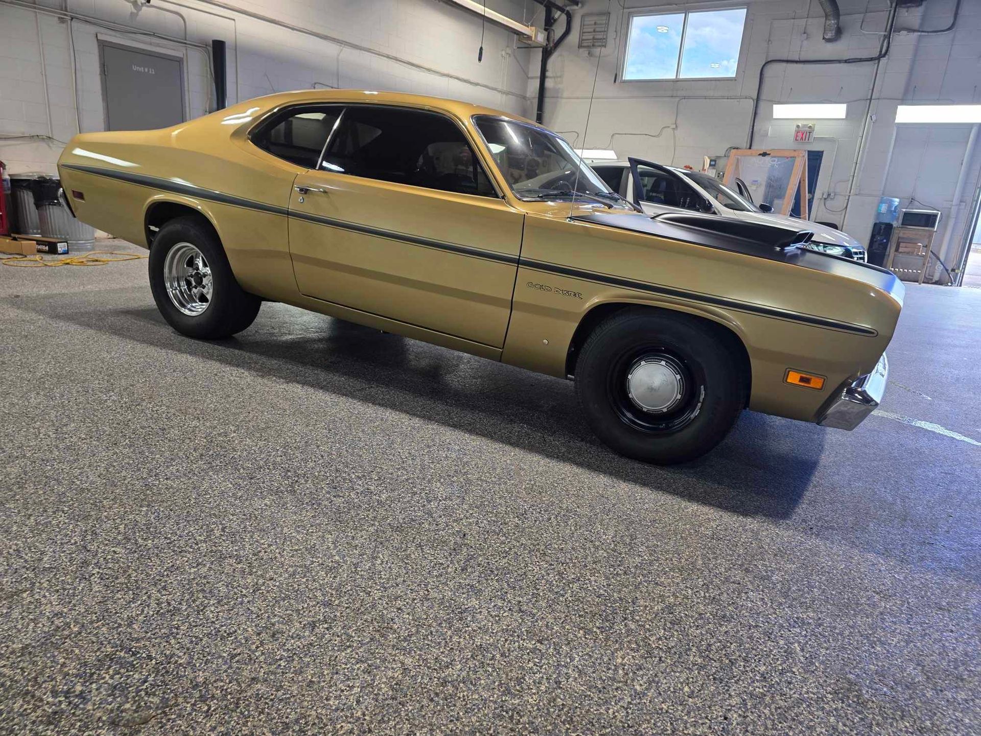Gold classic muscle car parked inside a garage.