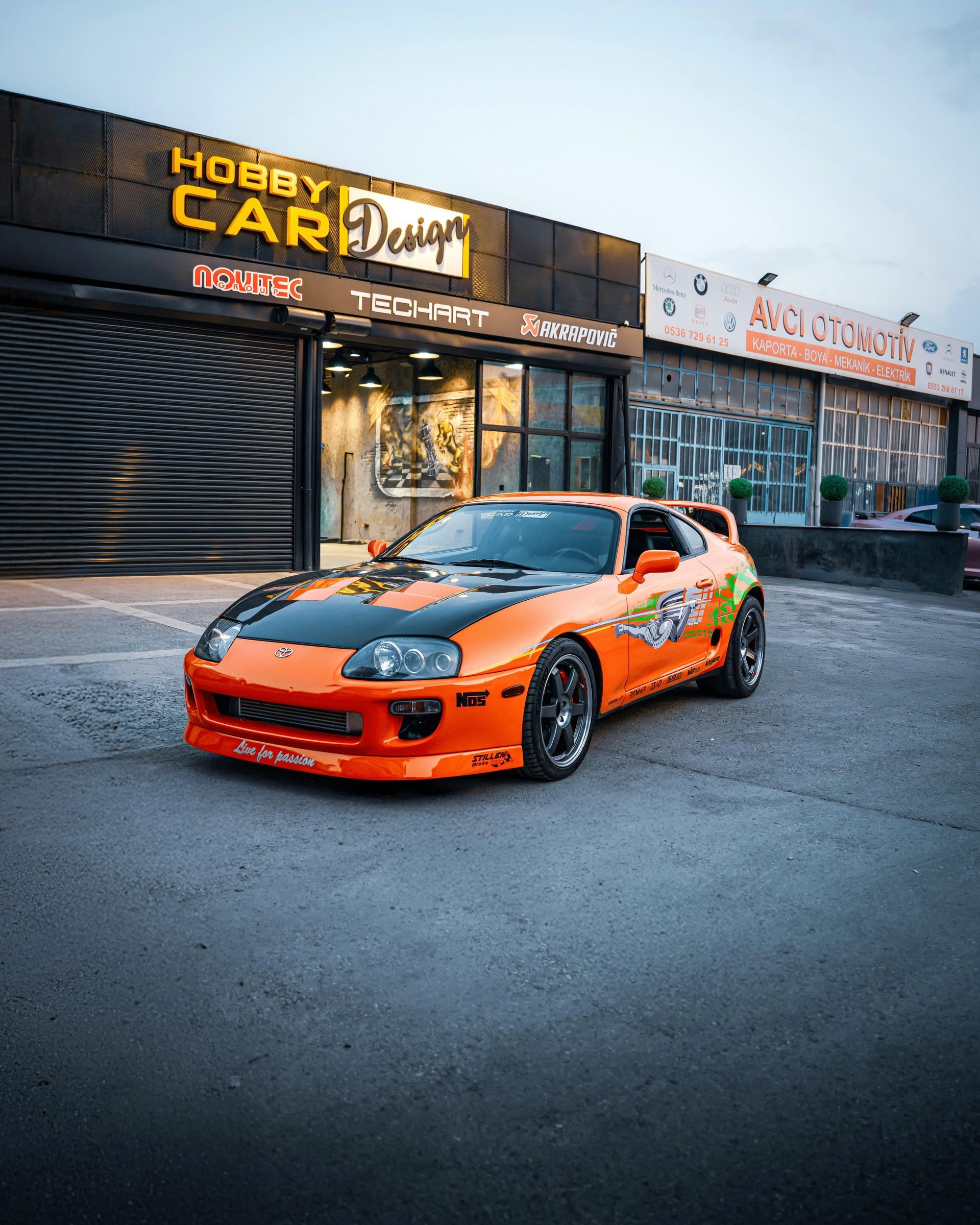 Orange and black Toyota Supra in front of