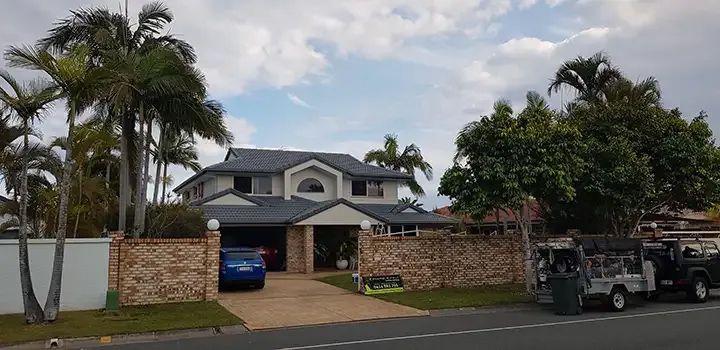 A Large House With A New Roof And Blue Car Parked In Front Of It — Enduro Shield Roofing Solutions in Elanora, QLD