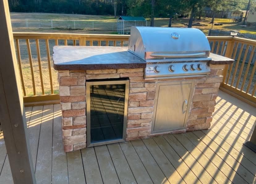 A grill is sitting on top of a wooden deck.