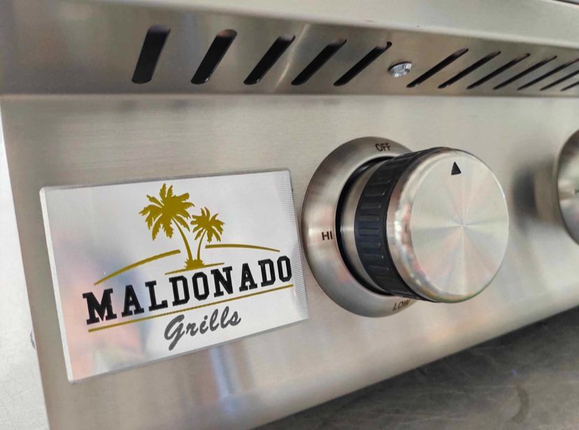 A close up of a maldonado grill with a palm tree on it